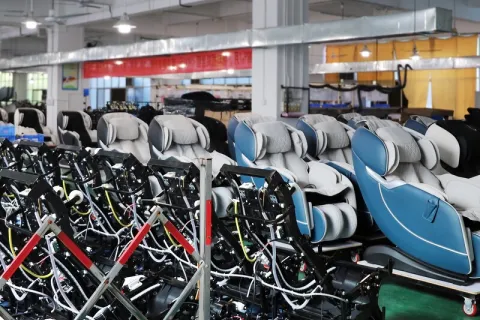 Finished massage chairs arranged in rows for storage before shipment.