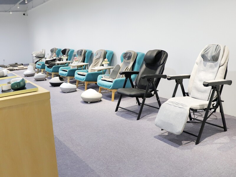 Massage chairs displayed in a showroom with different models arranged for viewing.