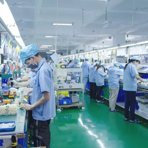 Factory operator checking products and components along a clean production line.