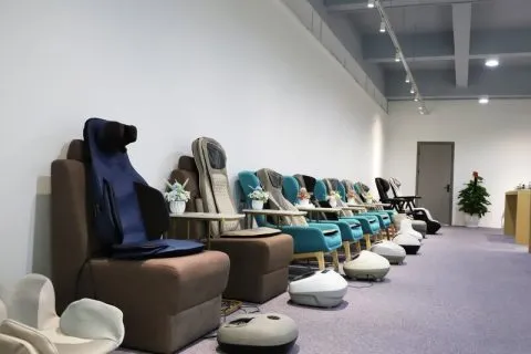 Relaxation and massage products displayed along the wall of a modern showroom.