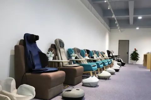 Relaxation and massage products displayed along the wall of a modern showroom.