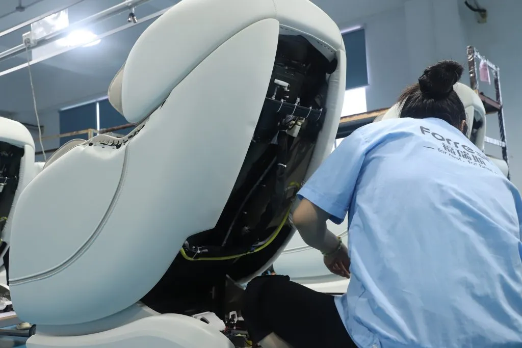 Inside Forrest's Shenzhen factory – skilled technicians assembling and testing massage chairs on the production line. Every unit verified before shipment.